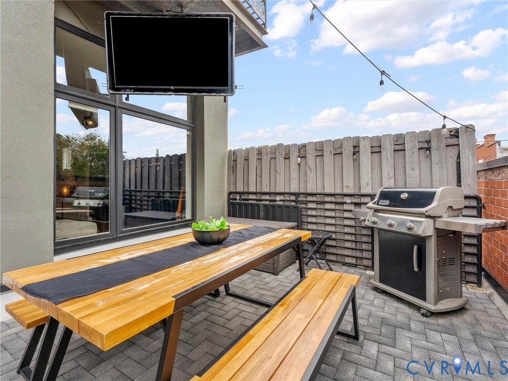 Patio featuring paver flooring, built-in privacy fencing, and string lighting