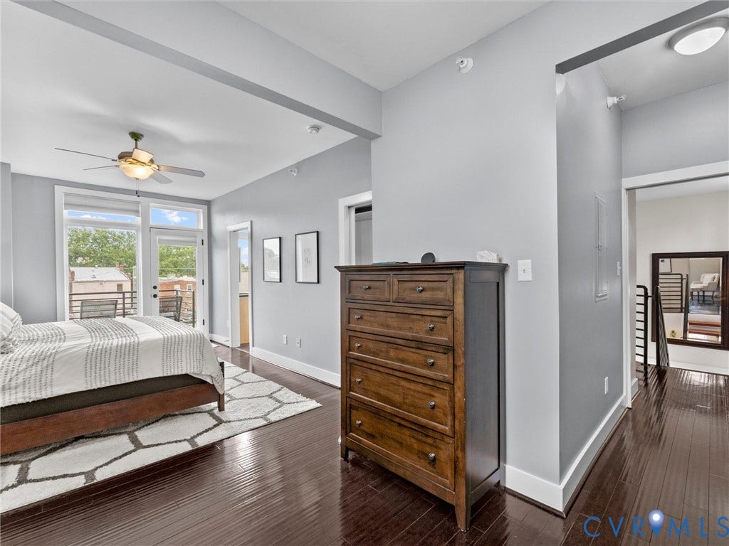 Wood-finish flooring, ceiling fan with integrated lighting, transom windows, and white trim