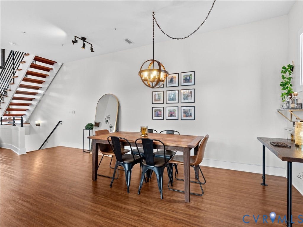 Wood-finish flooring throughout, with a wood-tread staircase featuring an open black metal balustrade