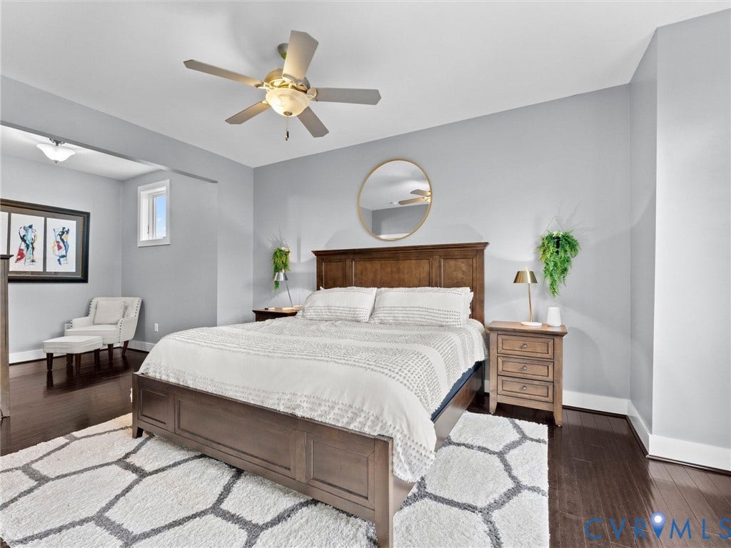 Dark wood-finish flooring, ceiling fan, recessed lighting, and a large window