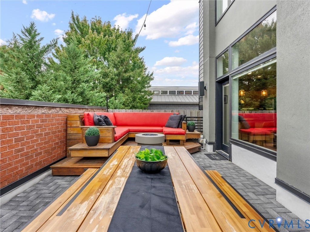 Outdoor patio featuring brick wall and wood decking