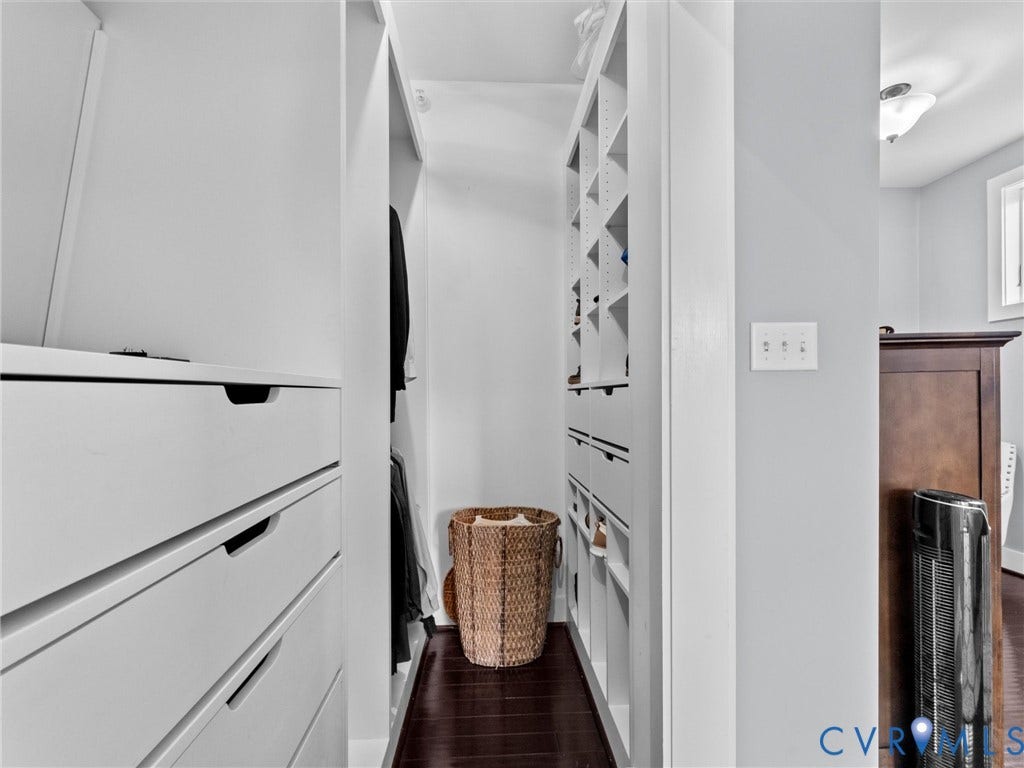 Built-in closet system featuring white cabinetry, integrated drawers, and shelving