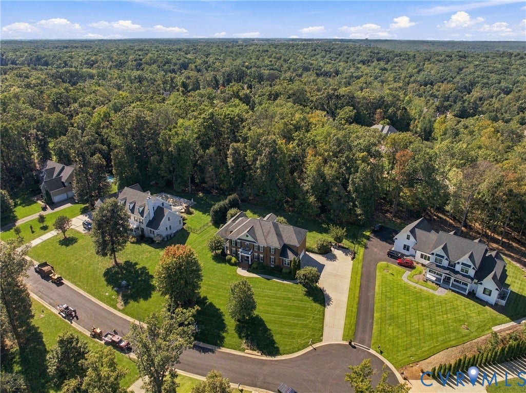 Expansive residential properties featuring manicured lawns, mature trees, and paved driveways