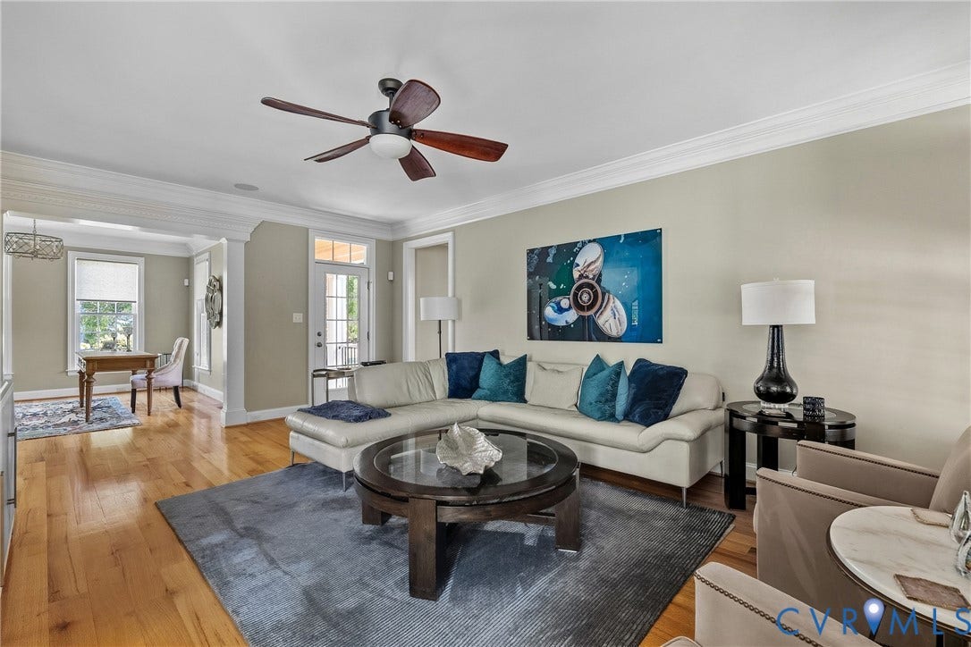 Hardwood flooring, crown molding, ceiling fan with light fixture, recessed lighting, and a transom window above the exterior door