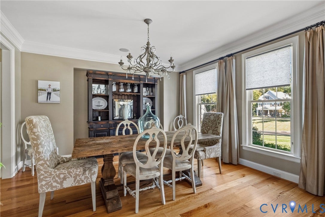 Hardwood flooring, crown molding, built-in cabinetry, dual windows, and chandelier lighting