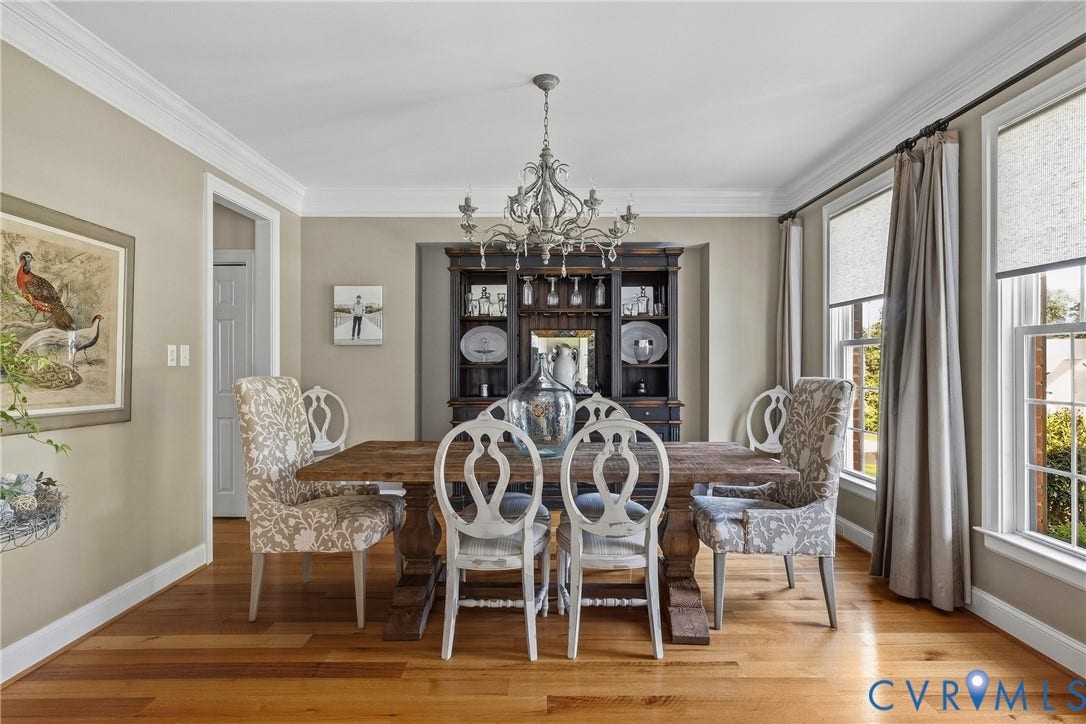 Hardwood flooring, crown molding, white trim, recessed window, and built-in cabinetry