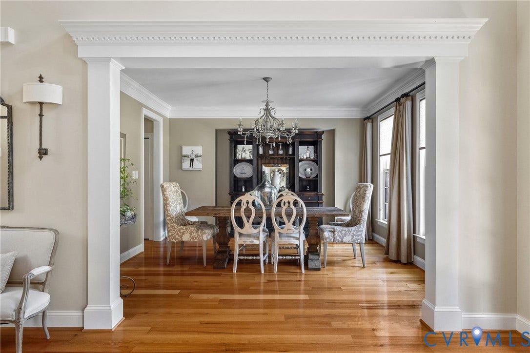 Hardwood flooring throughout, detailed crown molding, formal archway entry, and multiple tall windows