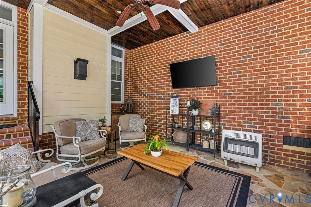 Covered patio featuring a wood-finish ceiling, brick walls, and flagstone flooring