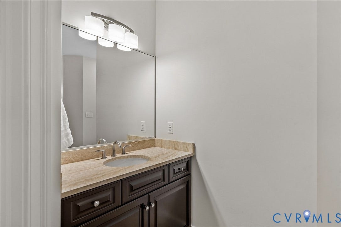 Vanity with a light-toned countertop, undermount sink, and brushed nickel faucet