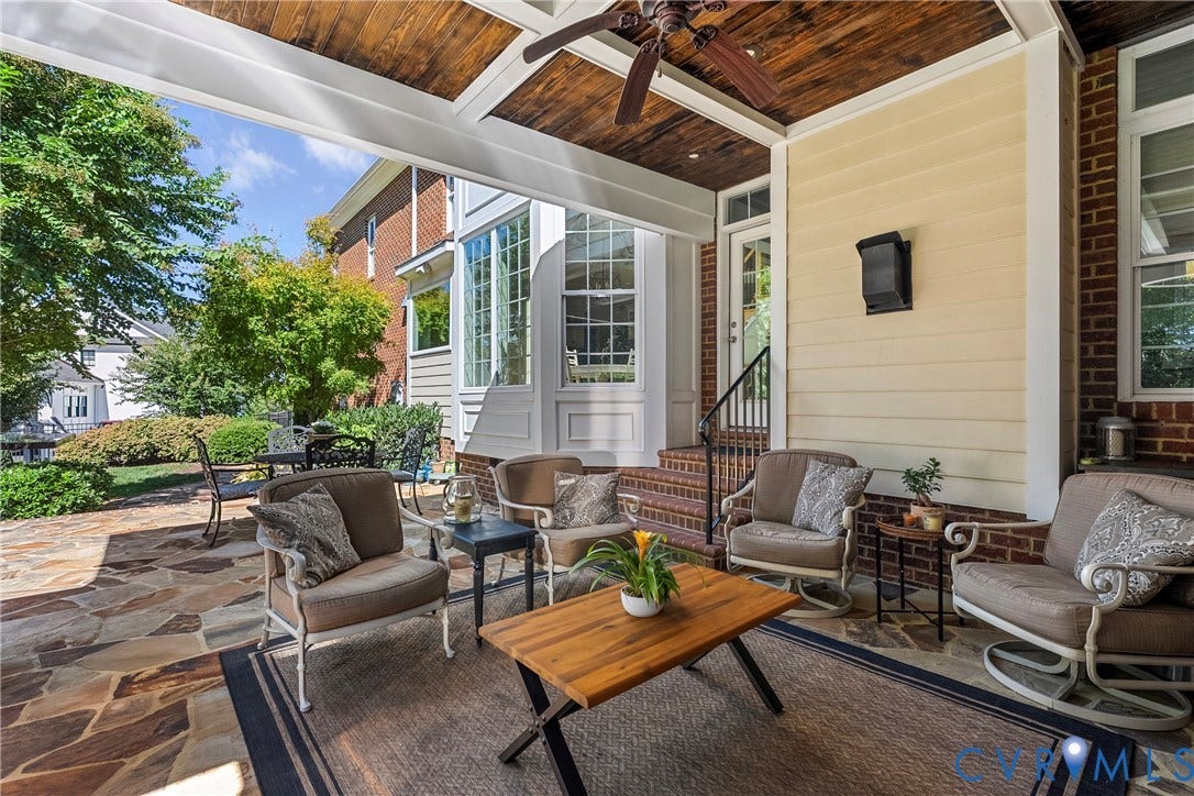Covered patio with a stone tile floor and a wood-paneled ceiling