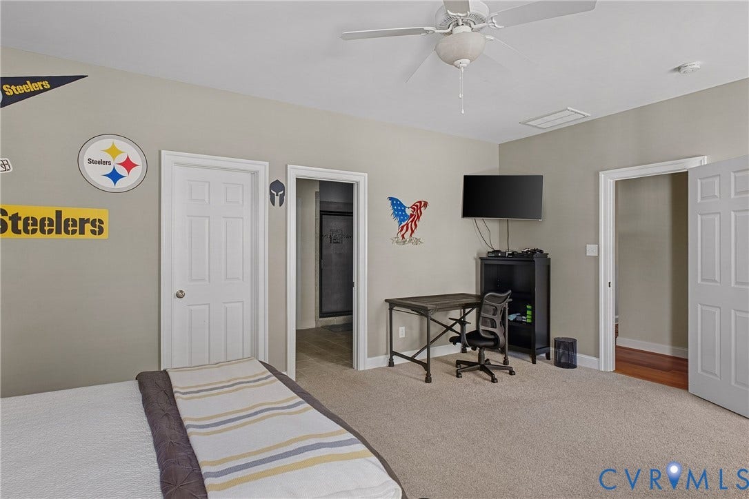Carpeted flooring, ceiling fan, neutral wall paint, white trim, multiple paneled doors