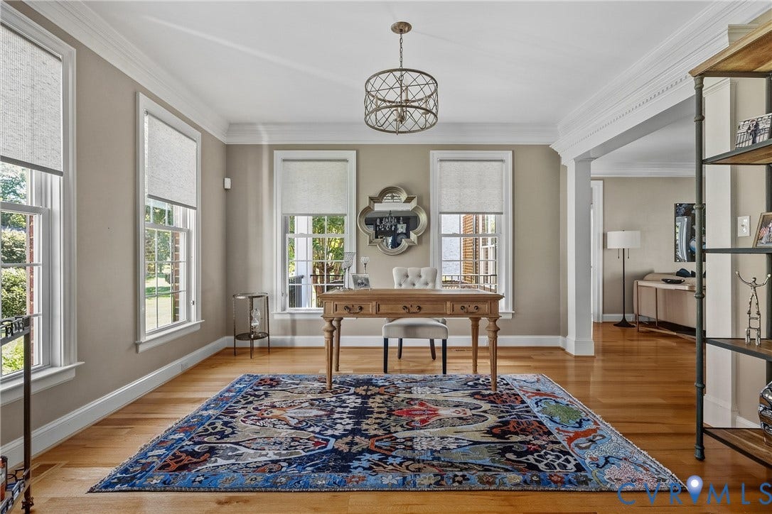 Hardwood flooring, crown molding, double-hung windows, and a decorative chandelier