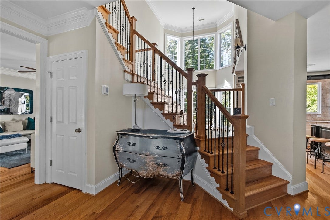 Hardwood flooring, custom iron balusters, hardwood staircase, extensive crown molding, and bay windows