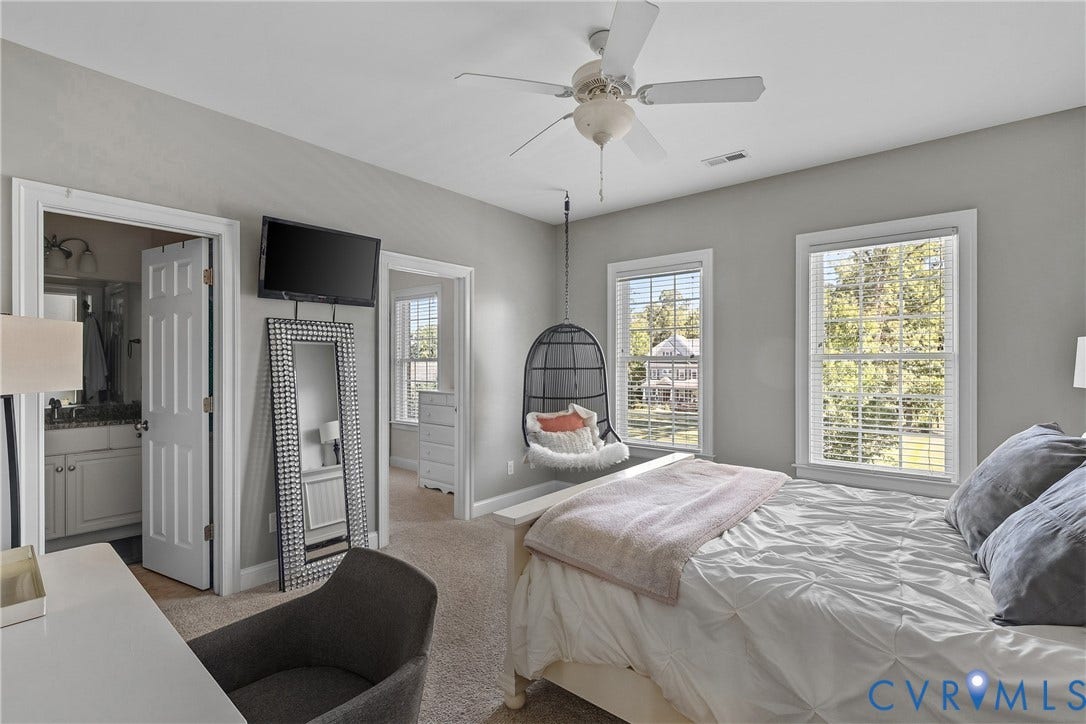 Carpeted room with a ceiling fan, two windows with blinds, and white trim