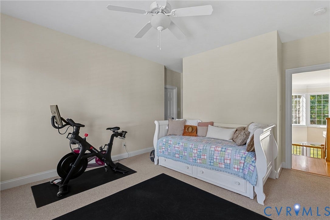 Wall-to-wall carpeting and a ceiling fan with integrated lighting