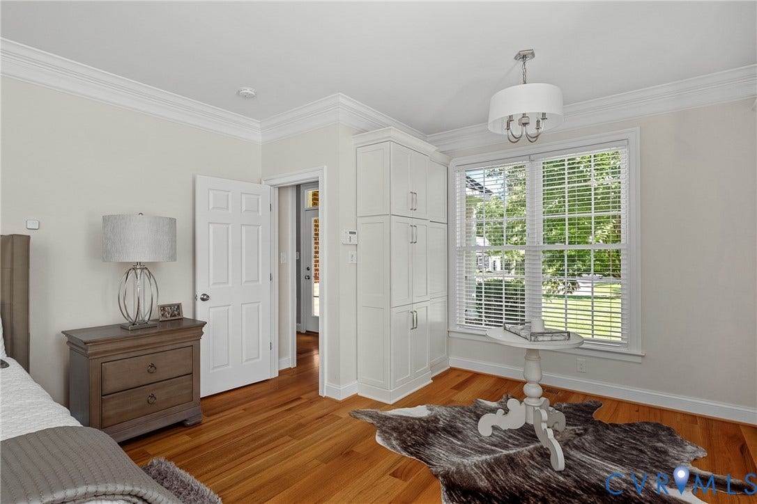 Hardwood flooring, built-in cabinetry, crown molding, double-hung windows, and a semi-flush mount light fixture