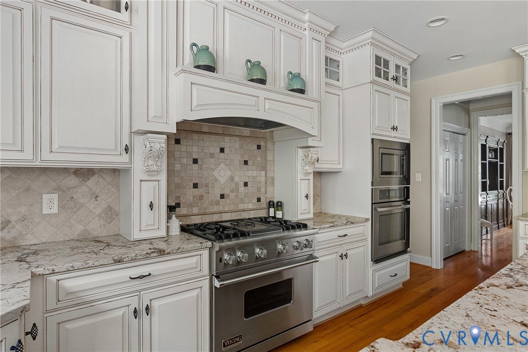 White cabinetry with decorative molding and glass-front upper cabinets