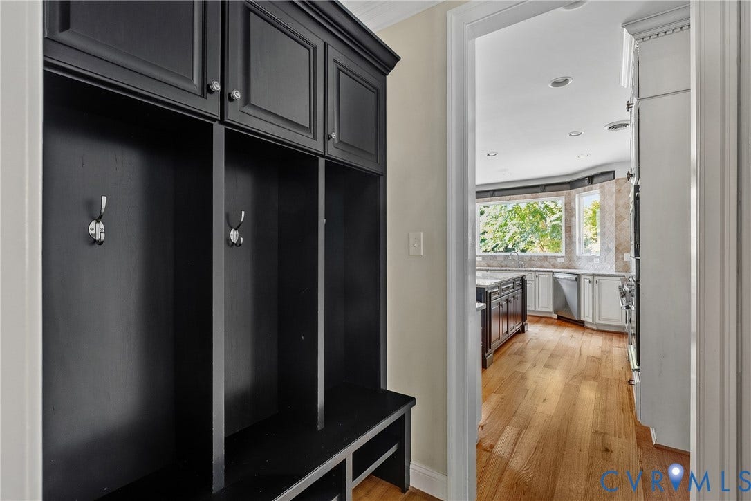 Built-in black cabinetry with chrome hardware, open shelving, and integrated bench seating