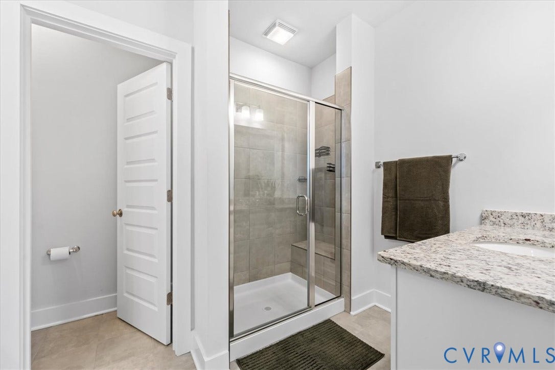 Walk-in shower with glass enclosure and tiled surround