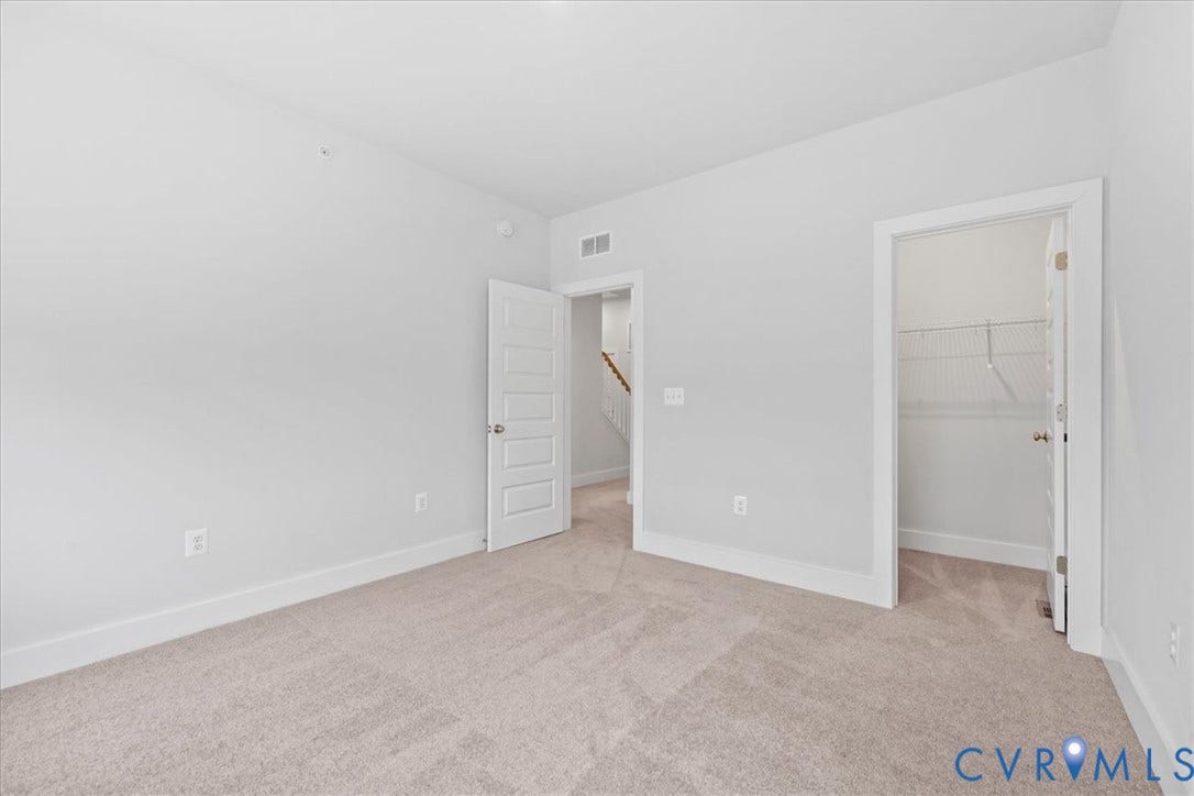 Neutral-toned carpeting, white walls, and white trim