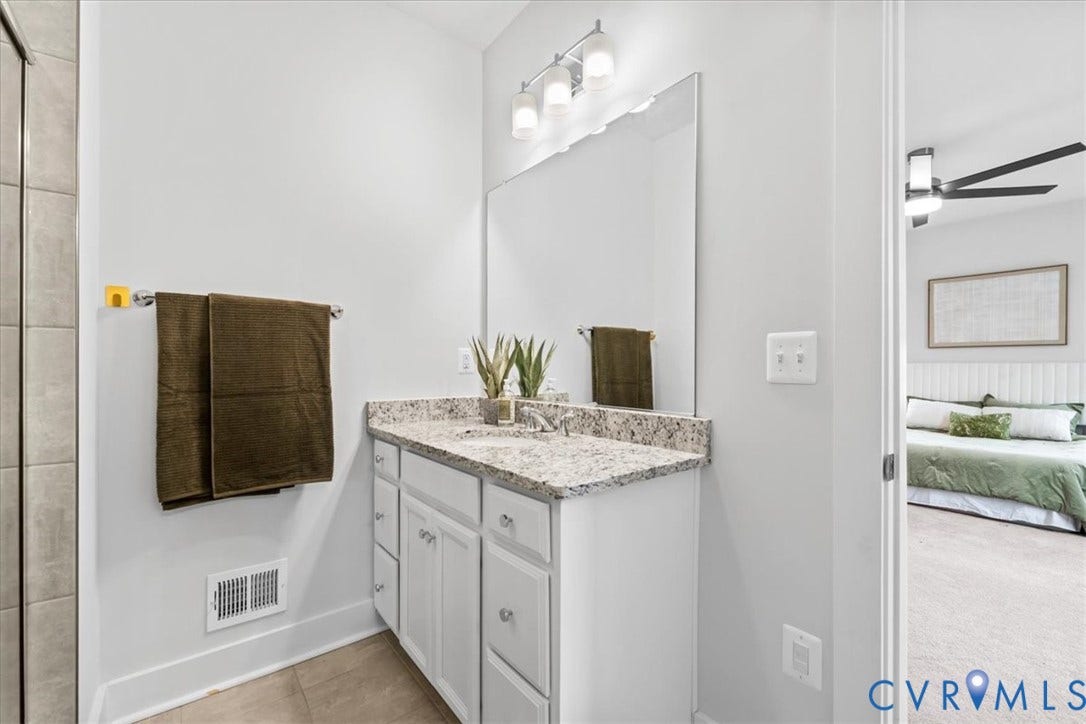 White vanity with shaker-style cabinetry, granite countertop, undermount sink, and polished chrome hardware