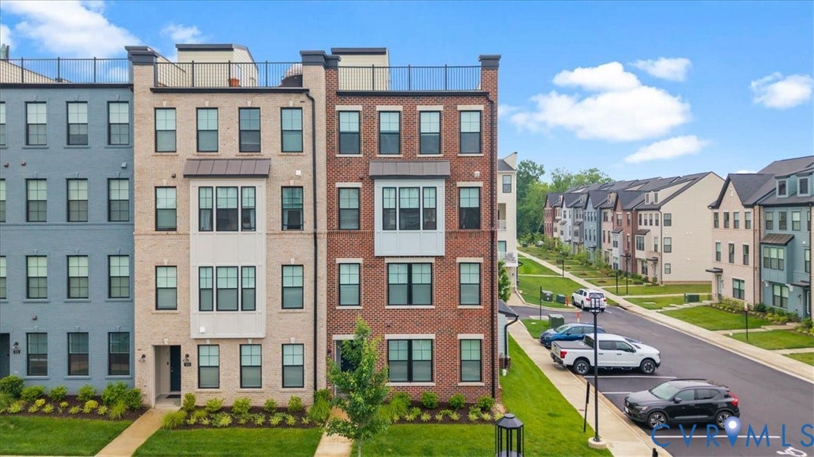 Brick and masonry exterior with multiple windows and a rooftop railing