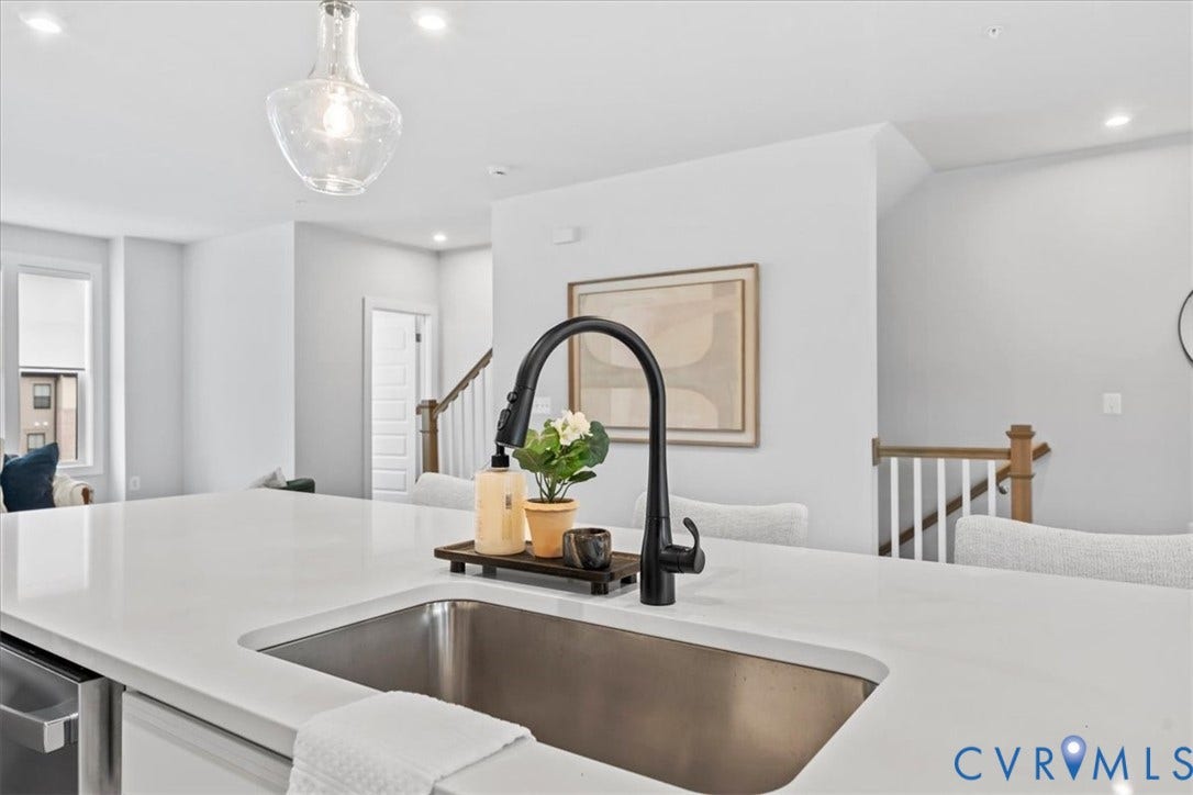 Kitchen island featuring a single-basin stainless steel sink with a matte black gooseneck faucet