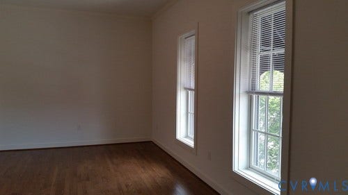 Hardwood-finish flooring, white trim, crown molding, and two double-hung windows