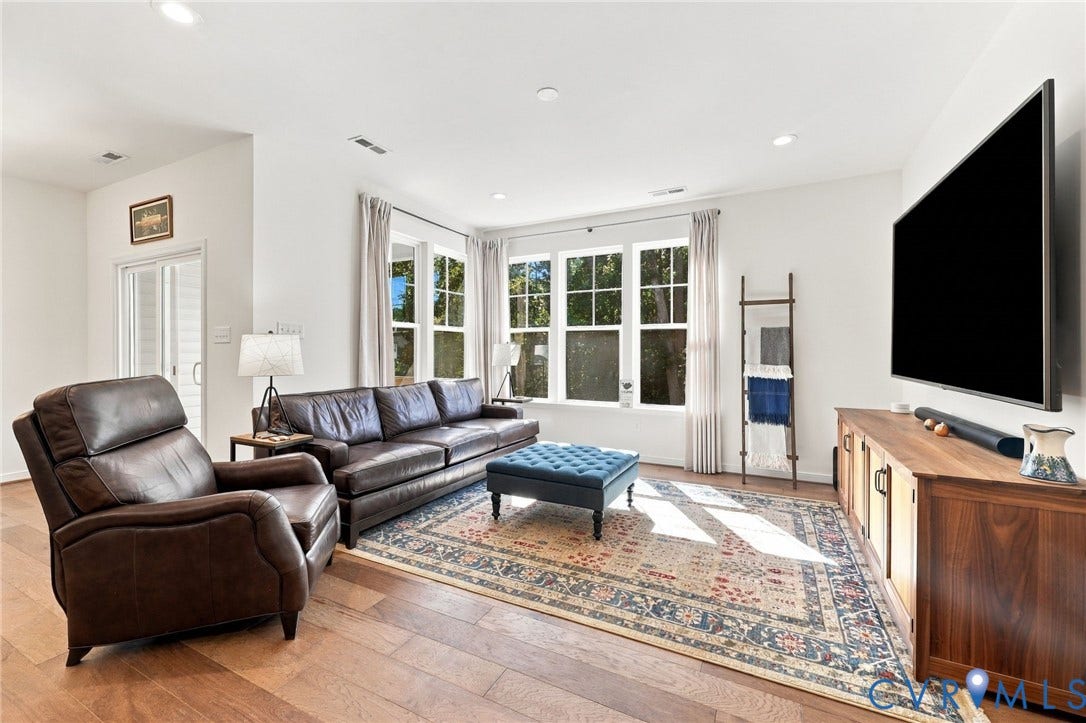 Hardwood-finish flooring, recessed lighting, and multiple windows with draperies