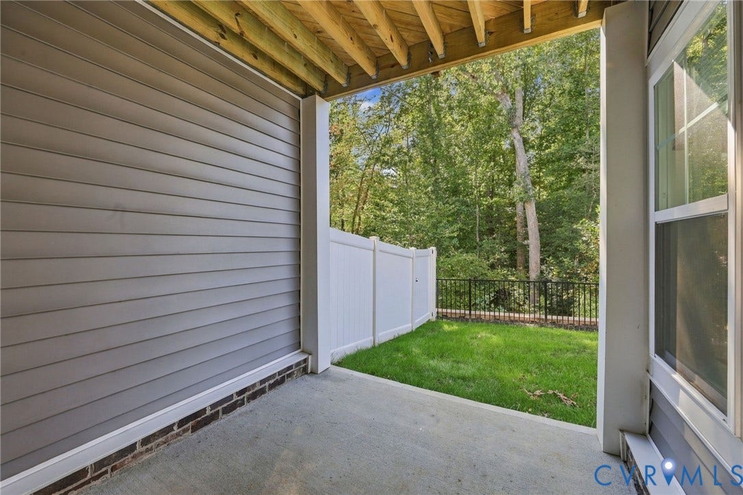 Basement Concrete patio with a slatted siding exterior and brick foundation