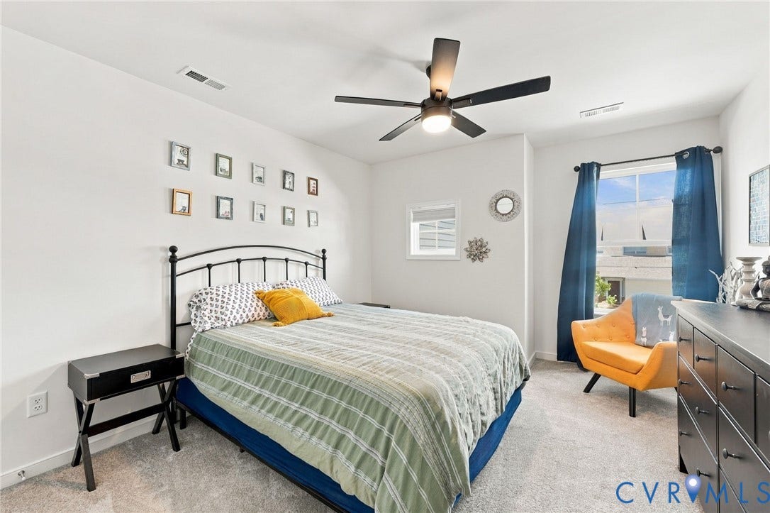 Carpeted room with a ceiling fan, recessed window, and white walls