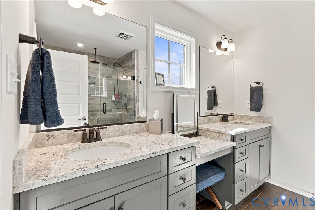Dual vanities with integrated sinks, light-colored countertops, and gray cabinetry