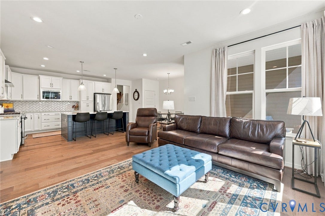 Open concept living area featuring wood-finish flooring, recessed lighting, and large windows