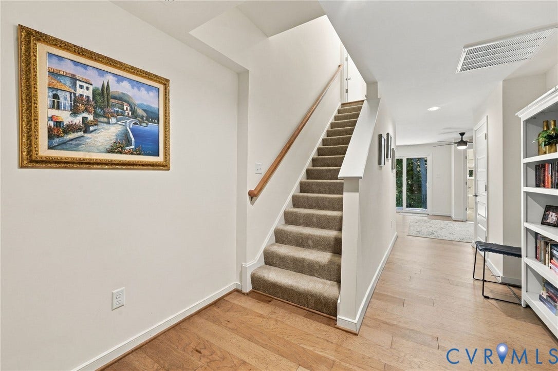 Hardwood-finish flooring extending through a brightly lit hallway