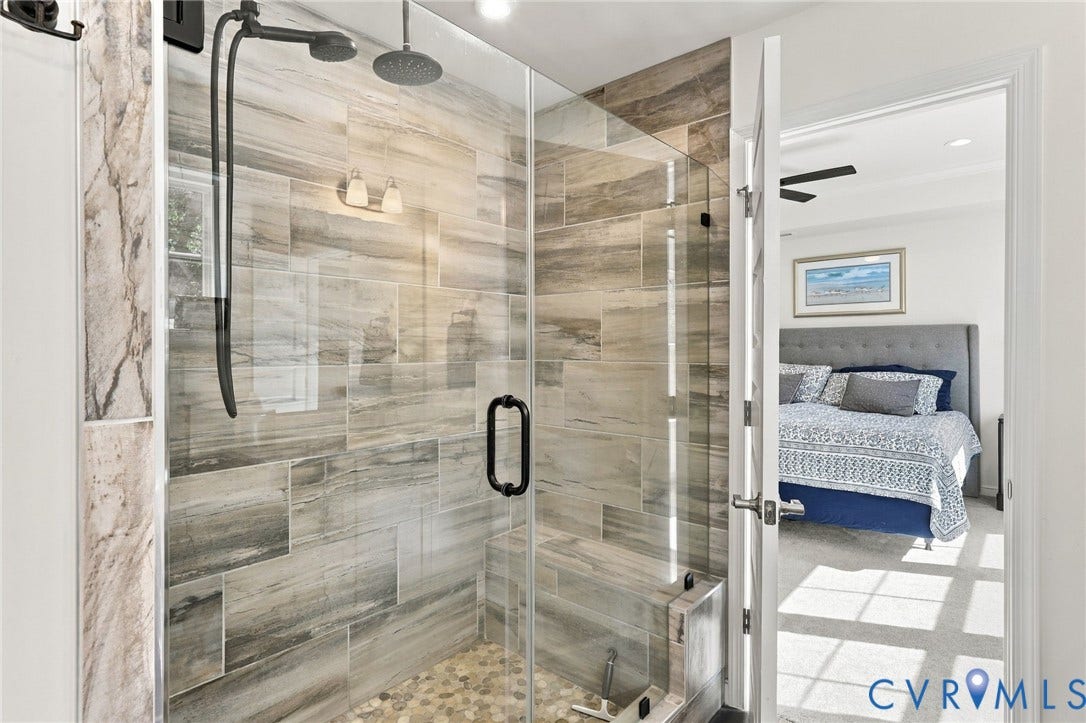 Frameless glass shower enclosure with a built-in bench