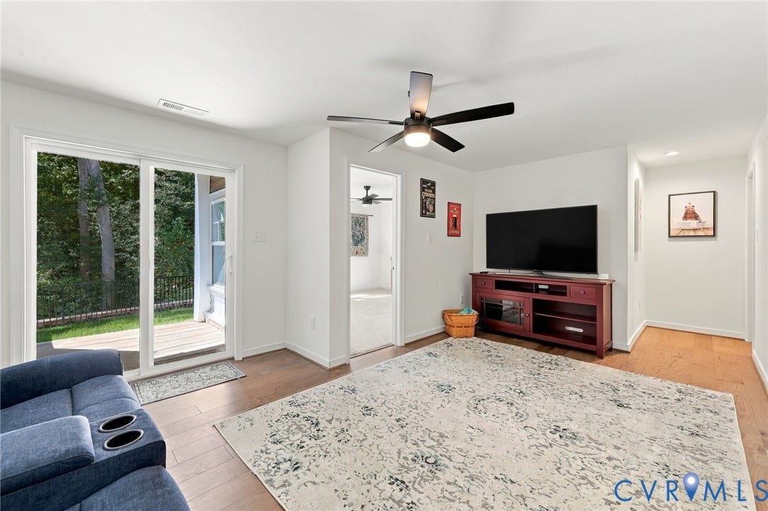 Sliding glass door leading to an outdoor deck, wood-finish flooring, ceiling fan with integrated lighting, recessed lighting, and white walls