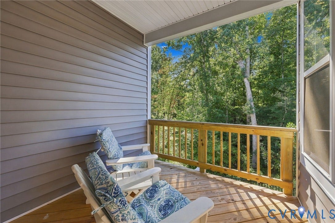 Covered outdoor porch featuring wood-finish decking and a natural wood railing