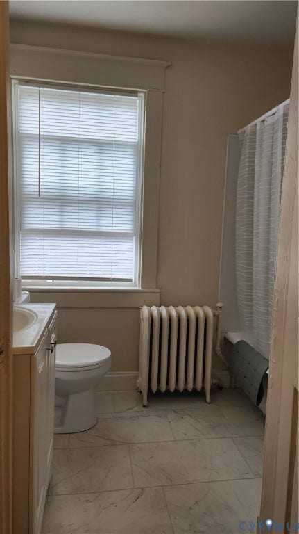 White tile flooring, single vanity, toilet, and a window
