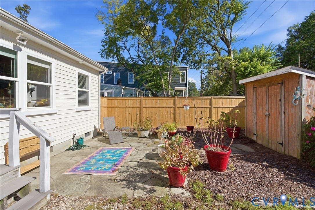 Private backyard featuring a wood privacy fence, concrete patio, and a wood storage shed