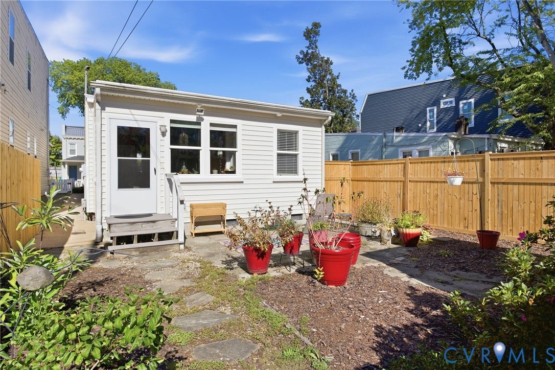 Enclosed backyard featuring wood fencing and stepping stones