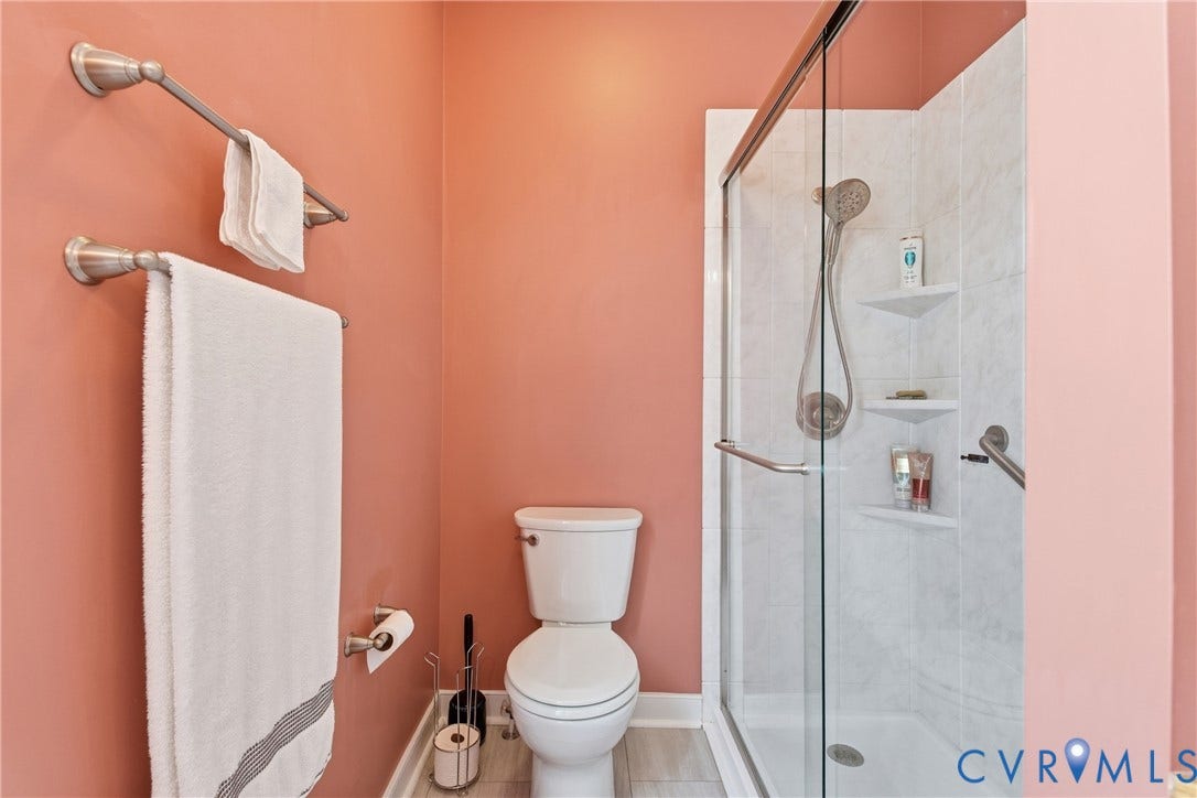 Walk-in shower with clear glass enclosure and built-in shelving
