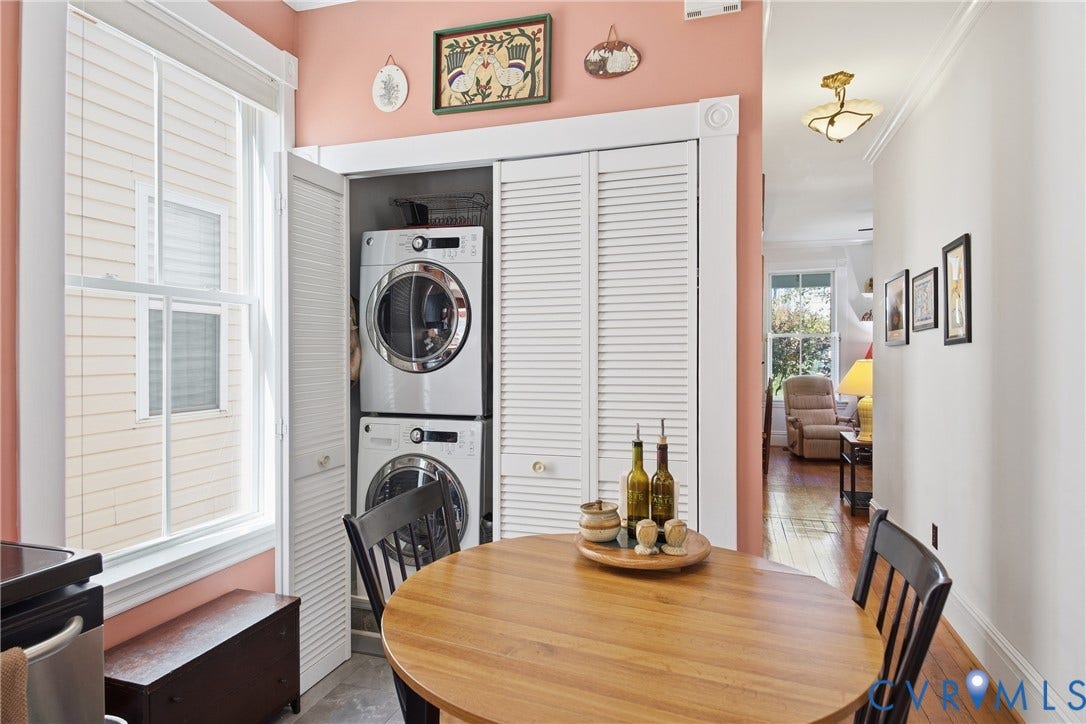 White louvered doors concealing a stacked washer and dryer
