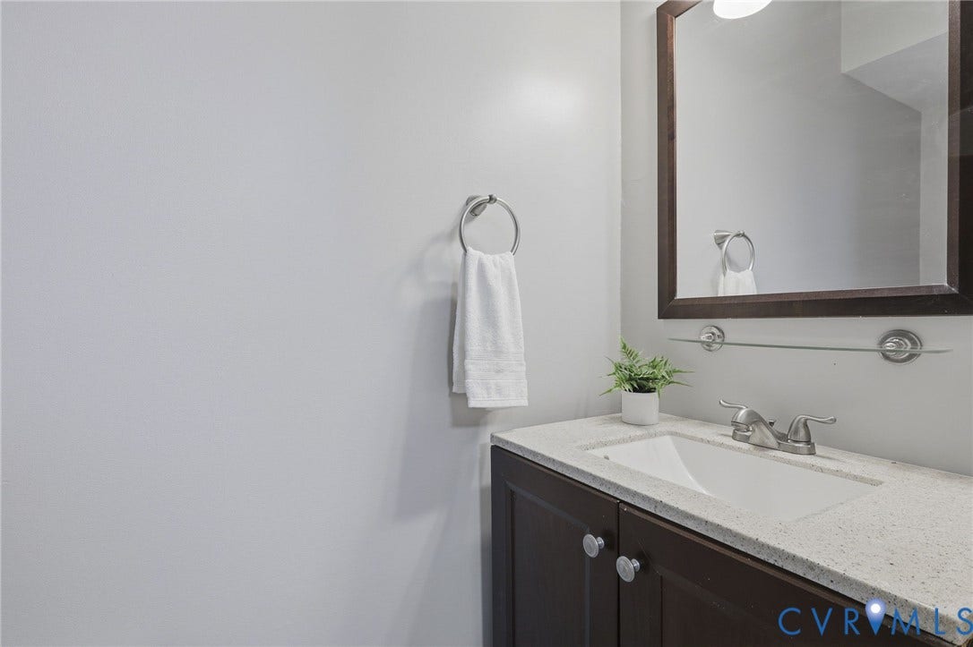 55 Dehaven Drive, Henrico, VA 23238 Dark wood-finish vanity with silver-tone hardware, white undermount sink, and light speckled countertop