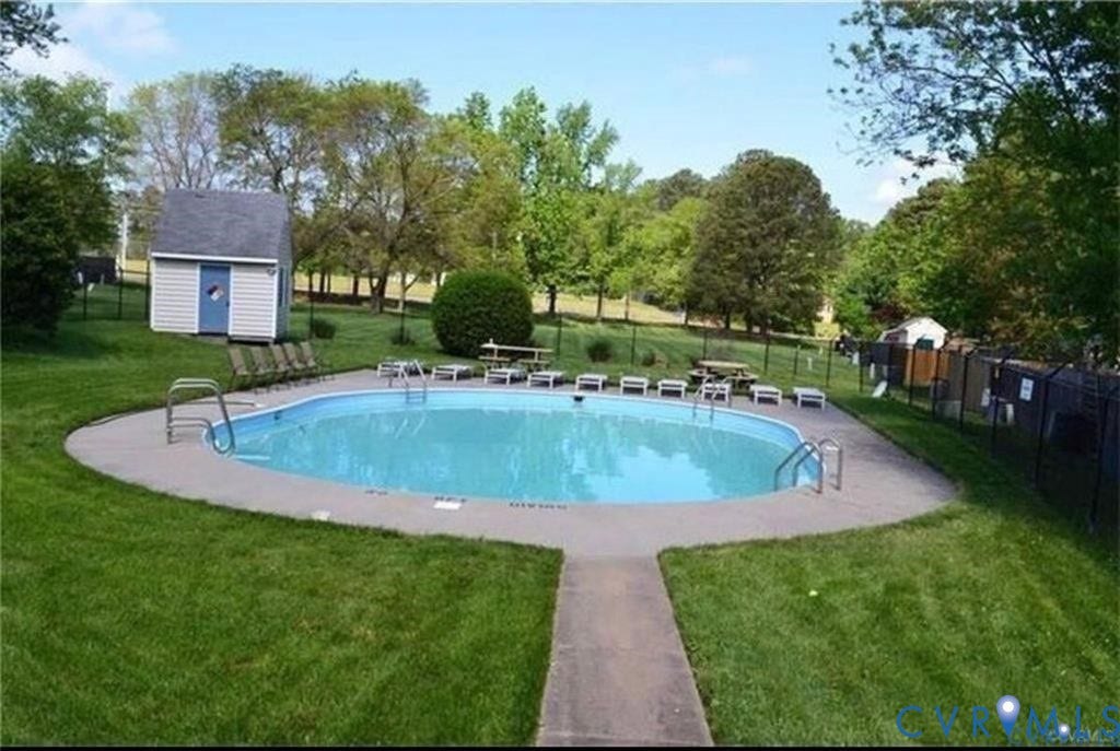 55 Dehaven Drive, Henrico, VA 23238 Oval swimming pool with concrete surround, expansive grass area, and a storage shed