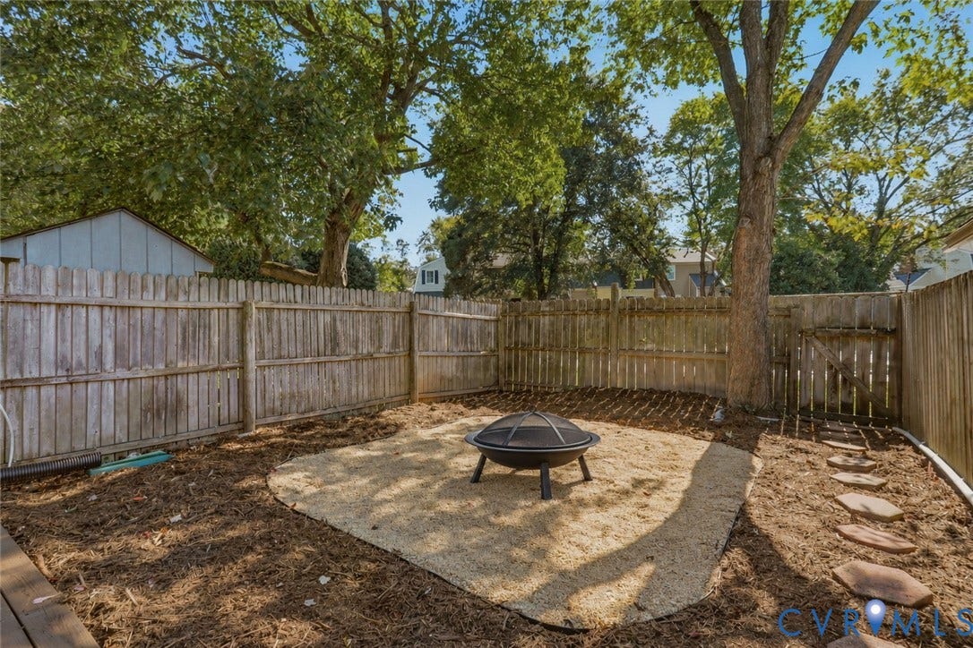 55 Dehaven Drive, Henrico, VA 23238 Wood privacy fence surrounding the backyard space with a gravel patio area and stepping stone path