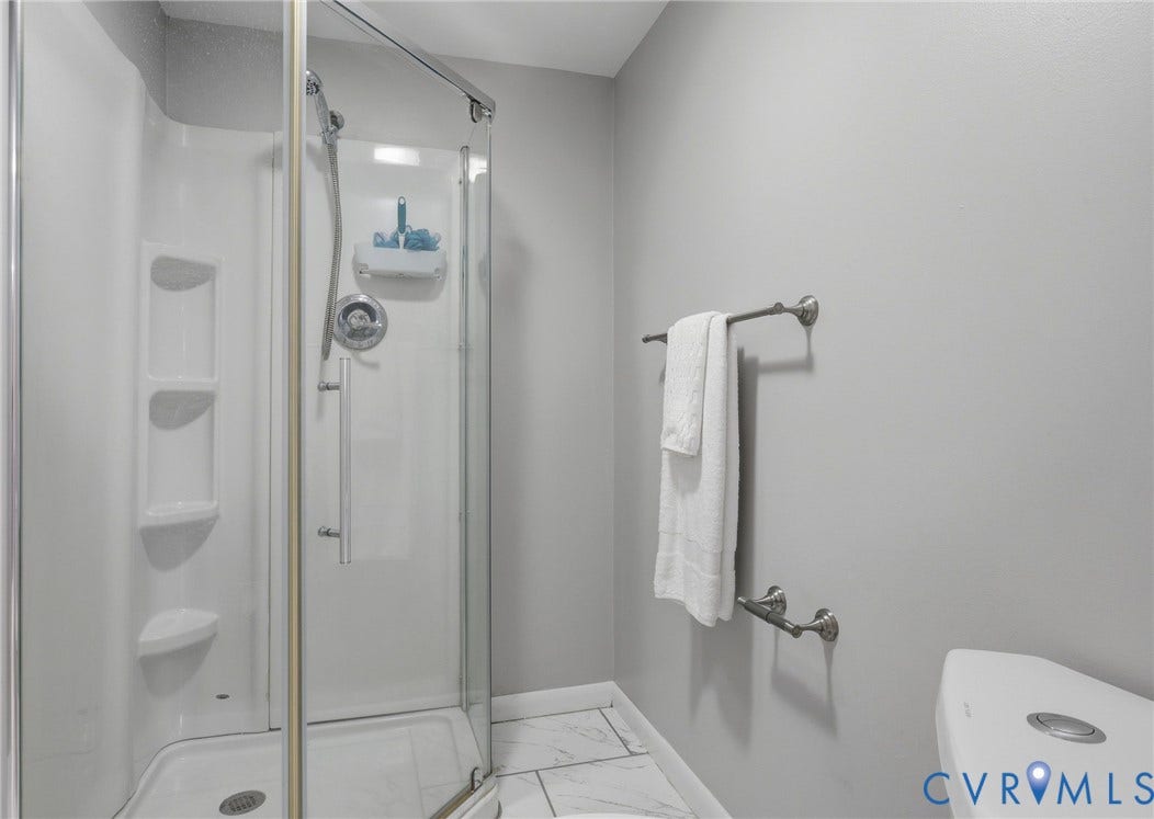 55 Dehaven Drive, Henrico, VA 23238 Shower enclosure with clear glass door, chrome fixtures, and built-in shelving