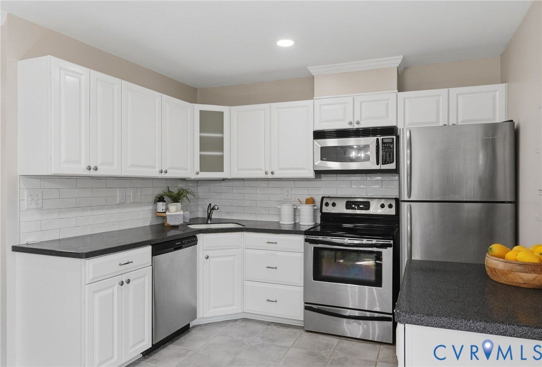 55 Dehaven Drive, Henrico, VA 23238 White cabinetry with silver hardware, dark countertops, white subway tile backsplash, stainless steel appliances, and gray tile flooring