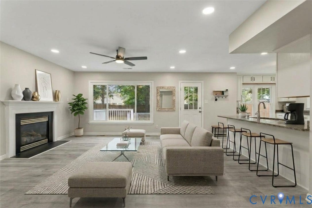 5831 Larrymore Road, Richmond, VA 23225 Open-concept interior featuring wood-finish flooring, a fireplace with a traditional mantel, recessed lighting, and a kitchen island with a stone countertop and breakfast bar seating