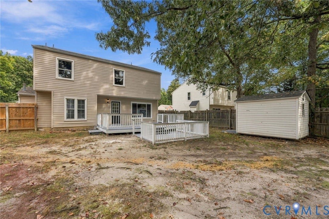 5831 Larrymore Road, Richmond, VA 23225 Two-story exterior with light-toned horizontal siding, multi-level exterior decking with white railings, and a detached storage shed enclosed by wood perimeter fencing