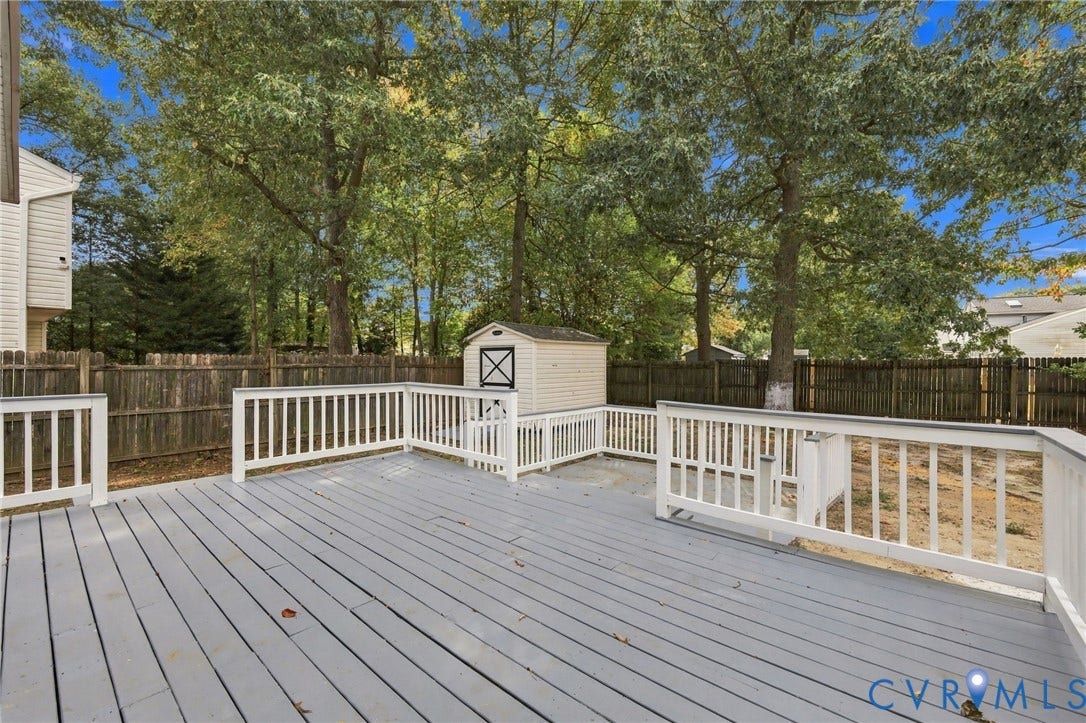 5831 Larrymore Road, Richmond, VA 23225 Raised wood-finish deck with white railings, enclosed by wood privacy fencing, and detached storage shed